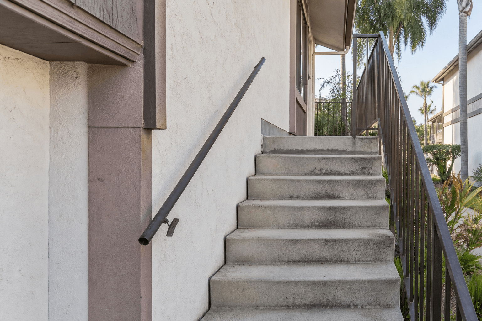 Loose and incomplete handrail beside an apartment stairway