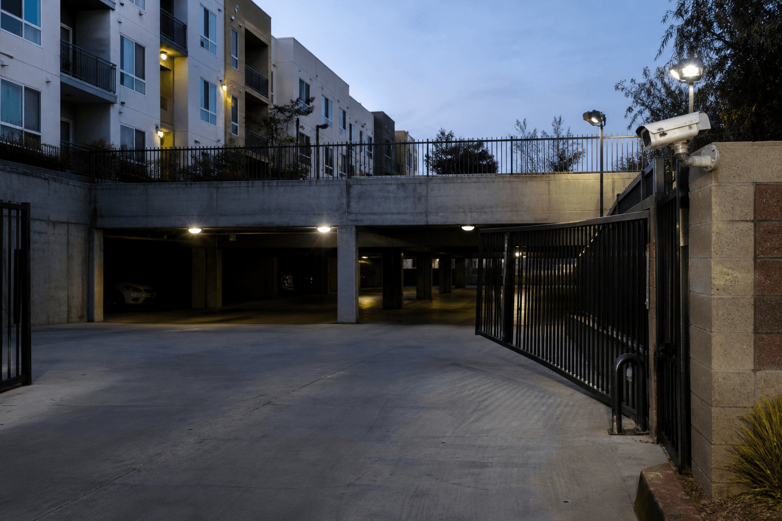 Apartment parking entrance with an open gate and security blind areas